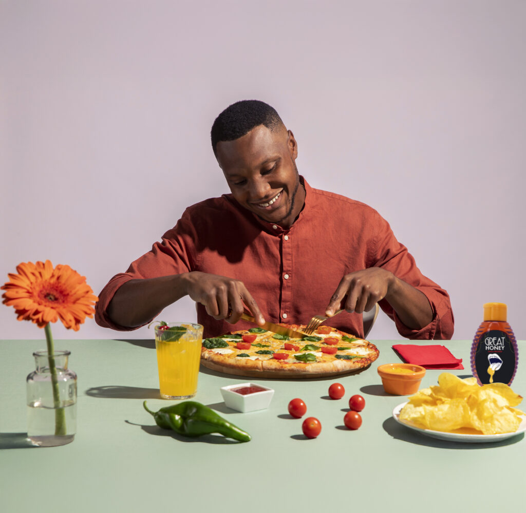 man eating pizza with hot honey